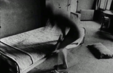Hooykaas/Stansfield, Daydreams, 1972 Black-and white image of a blurry figure changing in front of a one-person bed. Film still from Hooykaas/Stansfield, Daydreams, 1972.